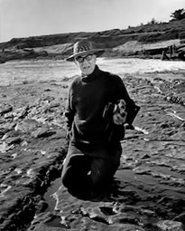 Wynn Bullock kneeling on the beach